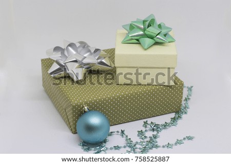 Two gift boxes with bows and a blue bead, Christmas ornamental beads on a light background