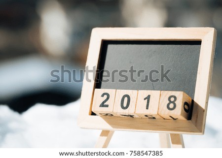 2018 NEW YEAR wooden blocks on black chalkboard background.