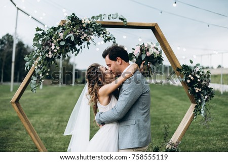 Soulful photo of the newlyweds hugging and kissing each other during the wedding ceremony Royalty-Free Stock Photo #758555119