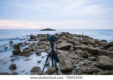 Camera on tripod shooting sunrise with seascape view