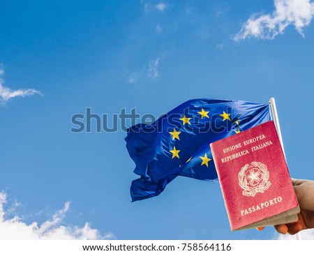 European Union (EU) flag against a blue sky with digital composite of woman holding an Italian passport