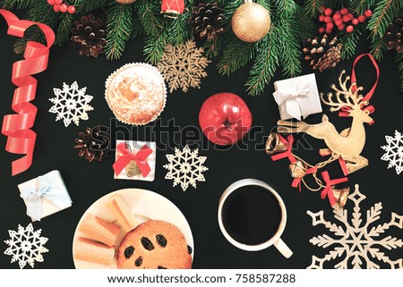 Christmas background or holiday card made beautiful composition gives New Year's mood. Ã?oncept of a festive Xmas table or breakfast. Black backtop is decorated deer, food, present, ball. Top view