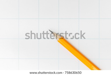 Yellow pencil with eraser lies on the paper in the cage for school.