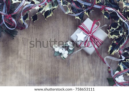 Gift boxes wrapped in rustic paper and rope. Photo frame with mistletoe and Christmas ribbon on wooden background. Place for text and top view