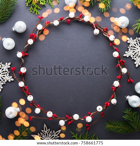 Frame with christmas wreath on dark background top view. Merry christmas greeting card. Winter xmas holiday theme. Happy New Year. Flat lay. Twinkle glitter bokeh light.