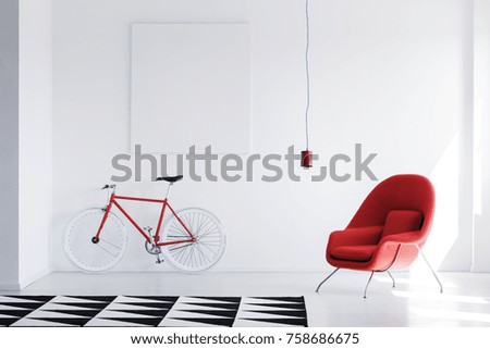 Mockup of white poster in white room with geometric carpet, red bicycle and armchair