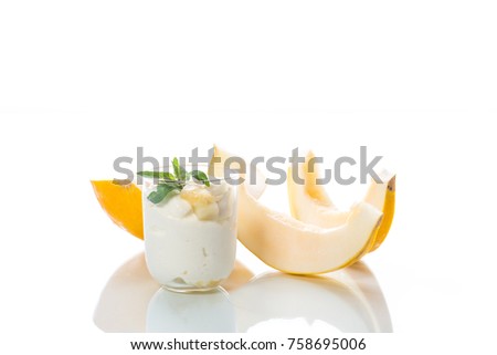 Homemade yogurt with slices of ripe melon in a glass cup