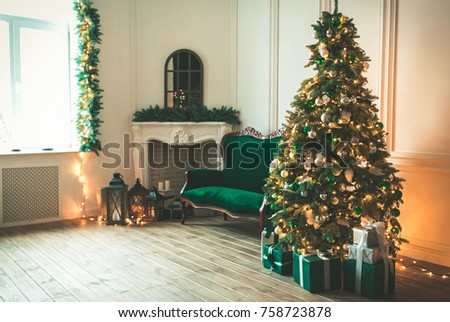 Christmas living room with a fireplace, sofa, Christmas tree and gifts. Beautiful New Year decorated classic home interior. Winter background.