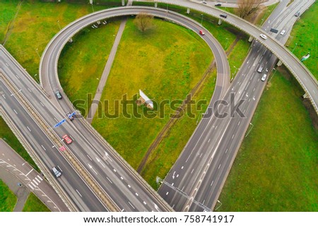 Aerial view at junctions of city highway. Vehicles drive on road