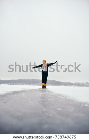 A girl in the penguin costume is have fun on ice in the winter.