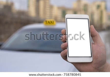 Close-up of a hand of a man holding a mobile phone in the background of a car and a city, booking a taxi. Mock up a clean smartphone screen for the design of your advertisement.