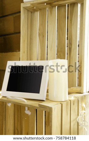 white frame and candle on wooden box and wooden background