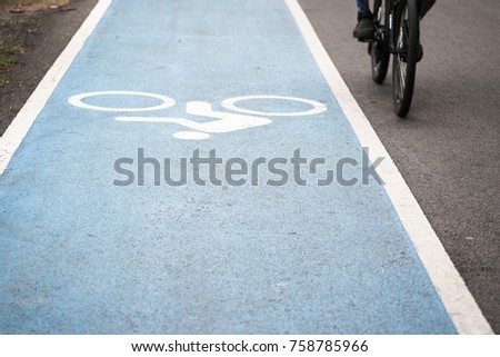 White Bicycle sign or icon painting to indicate road for bicycles on blue road with line designed to make cycling safe and movement of cyclist in the park.