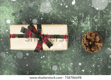 Box with gift for Christmas on a green background. Top view. Snow