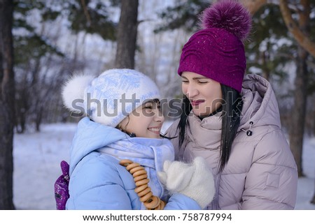 Christmas moments, winter picnic in a forest glade, happy mother and daughter walking in the Park in winter