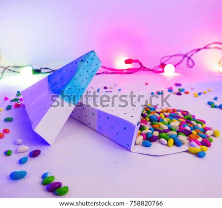 Christmas decoration triangle gift boxes with colorful candies close up photo in party lights for celebrations best Christmas holidays background image for invitation