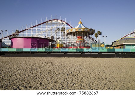 An old-fashioned amusement park with a beach boardwalk and an old wooden roller coaster. Royalty-Free Stock Photo #75882667