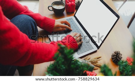 Business woman hand using laptop computer with blank screen on wooden desk, christmas and happy new year online shopping concept