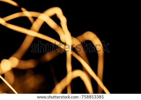 Xmas Golden transparent sparkles or glitter lights. Christmas festive gold background. Defocused lines bokeh or particles. Template for design