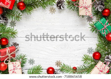 Christmas frame made of fir branches, festive decorations, gift boxes and pine cones on white wooden table. Christmas background. Flat lay. top view with copy space