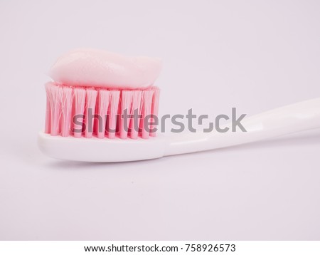 Toothpaste on a toothbrush close-up on a white light background