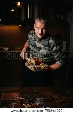 Portrait of friendly male professional confectioner and chef  Indoors image. Decorating and making pastry for Christmas. Traditional Hungarian food, named Bejgli.