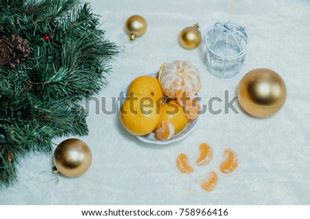 Tangerines are the green Christmas tree near the burning candles
