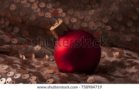 One lonely Christmas red mate ball on gold carpet. Vintage photo. New Year Theme