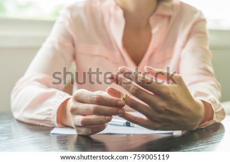 Great concept of divorce, ending of relationship, young woman pulling wedding ring from finger. Royalty-Free Stock Photo #759005119