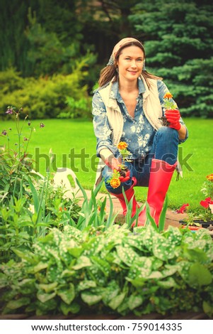 beautiful smiling middle-aged woman planting flowers in the flower garden. image filter retro style