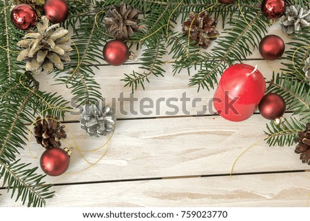 Christmas decoration with fir branches, cones and toys on white wooden background