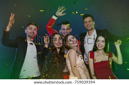 A party with friends. Happy and smiling friends at party with confetti.  People and holidays concept. Celebration and party. New year. Birthday