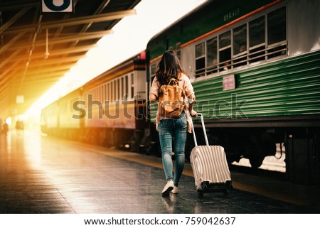 Woman traveler tourist walking with luggage at train station. Active and travel lifestyle concept Royalty-Free Stock Photo #759042637