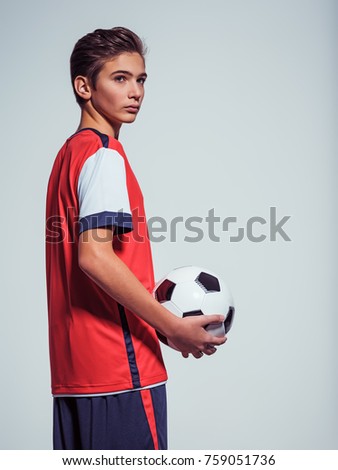 Photo of teen boy in sportswear holding soccer ball - posing at studio