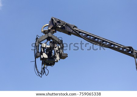 Professional camera on the crane against the sky