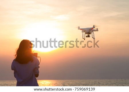 girl piloted UAV copter drone flying at sunset. UAV drone copter flying with digital camera.Drone with digital camera. 