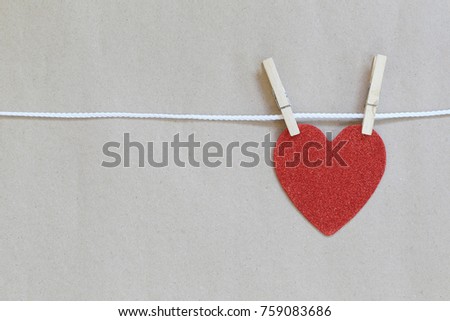 Red heart hanging on a rope and have copy space on brown background for design concept of love 