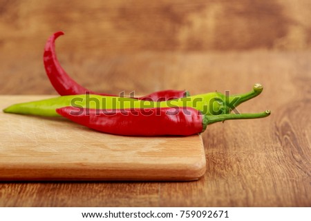 group of spicy red and green peppers on wooden Board