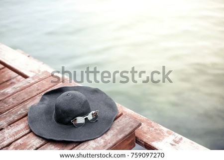 Hat, sunglasses on the beach on a sunny summer day,beach accessories on wooden board, vacation concept