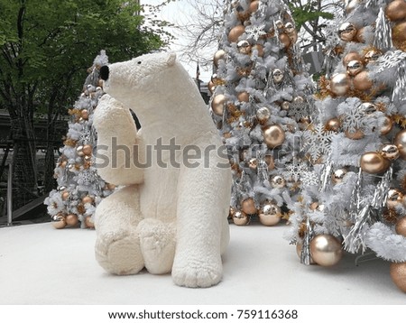 White bear doll and christmas decorated trees on the snow floor and city background 