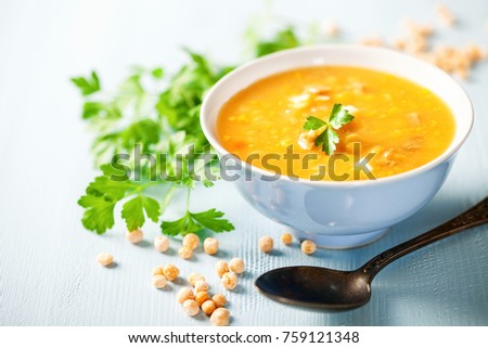Pea soup with pieces of bacon and parsley in a bowl on a blue background. Selective focus Royalty-Free Stock Photo #759121348