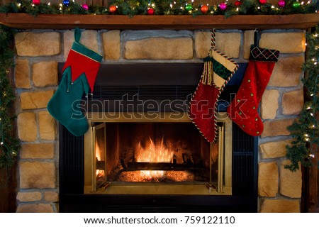 Three Christmas stockings hanging over a fireplace.