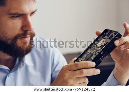 man carefully examines the hard drive.