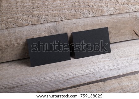 Photo of black business cards. Template isolated on old wood background. For graphic designers presentations and portfolios damaged weathered antique mock-up with black business cards