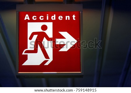 The emergency sign for Accident shows the direction of hazzard. The riskly exit for accident board hangs on the ceiling of the building.