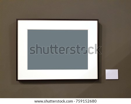 Empty photo frame on wall with empty label