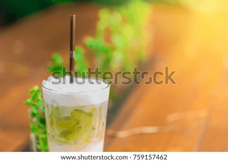 Green tea smoothies chilled on a wooden table in a coffee shop.