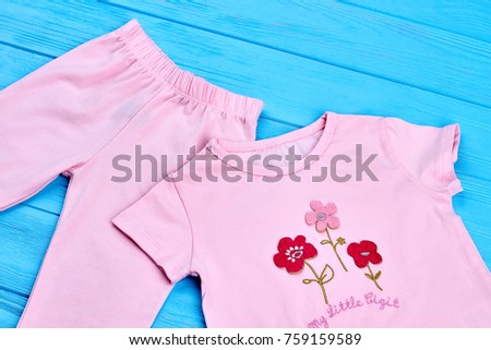 Close up of natural cotton baby suit. Pink leggings and t-shirt for toddler girl. Organic children clothes.