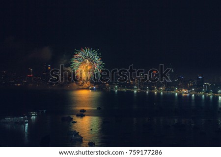 Beautiful colorful fireworks display on celebration night which reflection Sea at Pattaya beach, Thailand.