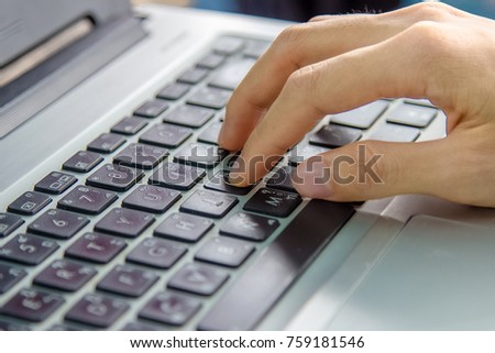 Girl's hand typing on keyboard of labtop